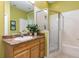Bright bathroom featuring a vanity with a sink, framed mirror, and a glass-enclosed shower at 9051 Treasure Trove Ln # 505, Kissimmee, FL 34747