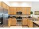 Kitchen featuring stainless steel appliances, natural wood cabinets and tile flooring at 9051 Treasure Trove Ln # 505, Kissimmee, FL 34747