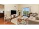 Inviting living room with hardwood floors, comfortable seating, and a sliding door to the balcony at 9051 Treasure Trove Ln # 505, Kissimmee, FL 34747