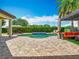 Lush backyard with a beautiful pool, lounge chairs, a covered cabana, and manicured landscaping at 9942 Hatton Cir, Orlando, FL 32832