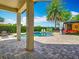 Inviting backyard pool area featuring a spacious patio, privacy hedge, and a tropical palm tree at 9942 Hatton Cir, Orlando, FL 32832