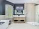 Modern bathroom featuring a soaking tub, vanity with lit mirror, and glass-enclosed shower with dual shower heads at 9942 Hatton Cir, Orlando, FL 32832