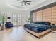 Stunning bedroom featuring tray ceilings, wood floors, doors to balcony, and a decorative panel wall at 9942 Hatton Cir, Orlando, FL 32832
