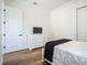 Bright bedroom with light hardwood floors, white walls, and TV atop a white dresser at 9942 Hatton Cir, Orlando, FL 32832