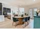 Dining room features an oval table, modern lighting, access to the kitchen, and a view to the backyard at 9942 Hatton Cir, Orlando, FL 32832