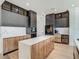 Well-appointed kitchen with black cabinets, wood island, marble counters, and a wine fridge at 9942 Hatton Cir, Orlando, FL 32832