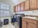Well-equipped laundry room with modern washer and dryer, upper cabinets, sink and natural light at 9942 Hatton Cir, Orlando, FL 32832