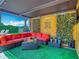 Relaxing outdoor lounge with comfy seating, lush green turf, privacy lattice and tropical decor at 9942 Hatton Cir, Orlando, FL 32832