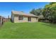 Lush backyard with a well-manicured lawn, patio, wooden fence, and the home's exterior at 100 Madden Ave, Sanford, FL 32773