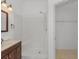 Bright bathroom featuring a vanity, walk-in shower and a doorway to a walk-in closet at 100 Madden Ave, Sanford, FL 32773