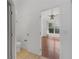 This bathroom leads to a bedroom with wood-look floors and a bright window at 100 Madden Ave, Sanford, FL 32773