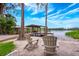 Beautiful backyard with two chairs facing a wooden deck and boathouse on the water at 1018 Turner Rd, Winter Park, FL 32789