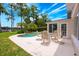 Backyard with patio and table set next to screened room and private pool at 1018 Turner Rd, Winter Park, FL 32789