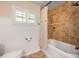 Bathroom features a tiled shower, a jet tub and a toilet and window with a white frame at 1018 Turner Rd, Winter Park, FL 32789