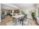 Bright dining area featuring a whitewashed dining table, wooden benches, and an open concept to the kitchen and living room at 1018 Turner Rd, Winter Park, FL 32789
