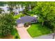 Aerial view of home with brick driveway, two-car garage and luscious landscaping on a lake at 1018 Turner Rd, Winter Park, FL 32789