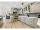 Updated kitchen with stainless steel appliances, sage green cabinets, and modern lighting at 1018 Turner Rd, Winter Park, FL 32789
