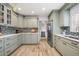 Well-equipped kitchen featuring sage cabinetry, modern appliances, and wood flooring at 1018 Turner Rd, Winter Park, FL 32789