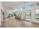 Open living space filled with natural light from large windows, featuring stylish furniture and wood-look flooring at 1018 Turner Rd, Winter Park, FL 32789