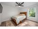 Bedroom showcasing a wooden bed frame with drawer storage, complemented by light-colored bedding and natural light from the window at 10241 Pointview Ct, Orlando, FL 32836