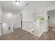 Upstairs hallway with white railings and an arched window overlooking the front yard at 10241 Pointview Ct, Orlando, FL 32836