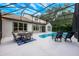 Outdoor living space with a pool, lounge chairs, and dining area under a screened enclosure, perfect for entertaining at 10241 Pointview Ct, Orlando, FL 32836