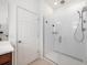 Modern bathroom featuring a glass-enclosed shower with sleek fixtures and a white door at 1027 Eagle Tree Ln, Sanford, FL 32771