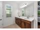 Well-lit bathroom with double sinks, a large mirror, a white countertop, and dark wood cabinets at 1027 Eagle Tree Ln, Sanford, FL 32771