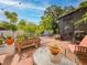 Paver patio in fenced backyard features outdoor seating, lush greenery, and a screened porch at 1041 N Fern Creek Ave, Orlando, FL 32803