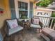 Close up of the front porch with cozy chairs, throw pillows and stone floor at 1041 N Fern Creek Ave, Orlando, FL 32803