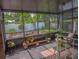 Spacious screened-in porch showcasing views of the fenced backyard, potted plants, and cozy seating area at 1041 N Fern Creek Ave, Orlando, FL 32803
