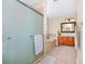 Bathroom offers a shower with glass door, bathtub, wood cabinets, framed mirror and tile floors at 1046 Morris Ave # 1046, Orlando, FL 32803