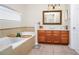 Bathroom offers a bathtub, wood cabinets, marble countertops, framed mirror and tile floors at 1046 Morris Ave # 1046, Orlando, FL 32803