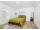 White bedroom features ceramic tile floors, a ceiling fan, minimal wall art, and a large mirror at 1046 Morris Ave # 1046, Orlando, FL 32803