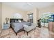 Bright bedroom features neutral walls, ceramic tile floor, ceiling fan, and a sliding glass door with balcony access at 1046 Morris Ave # 1046, Orlando, FL 32803