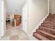 Inviting entryway featuring travertine floors, a staircase with wood treads, and an open view into the kitchen at 1046 Morris Ave # 1046, Orlando, FL 32803