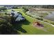 A charming home with a sprawling lawn, playset, and white fence bordering a natural wetland area, seen from an aerial perspective at 10809 Arrowtree Blvd, Clermont, FL 34715