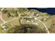 An aerial view of a large property with a house, outbuildings, pool, tennis court, and extensive lawns near a body of water at 10809 Arrowtree Blvd, Clermont, FL 34715