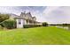 Beautiful backyard featuring lush green grass, manicured shrubs, and a covered back porch at 10809 Arrowtree Blvd, Clermont, FL 34715