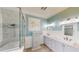 Well-lit bathroom features dual vanities, a glass shower enclosure, and stylish fixtures at 10809 Arrowtree Blvd, Clermont, FL 34715