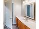 Well-lit bathroom featuring a marble countertop, wood cabinets, and decorative framed mirror at 10809 Arrowtree Blvd, Clermont, FL 34715