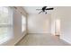 Neutral bedroom with two windows, a ceiling fan, carpeted floors, and white trim at 10809 Arrowtree Blvd, Clermont, FL 34715