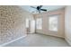 Bright bedroom with ceiling fan, two windows, neutral carpet and unique wallpaper accent wall at 10809 Arrowtree Blvd, Clermont, FL 34715