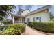 Home exterior featuring a covered porch with white railing, green shutters, and manicured landscaping at 10809 Arrowtree Blvd, Clermont, FL 34715