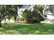 Charming two-story home with a welcoming front porch, mature trees, and a lush green lawn, creating a serene atmosphere at 10809 Arrowtree Blvd, Clermont, FL 34715