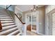 Inviting foyer with staircase, tile flooring, chandelier, and access to rooms with French doors at 10809 Arrowtree Blvd, Clermont, FL 34715