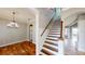 Elegant foyer with hardwood floors, staircase, chandelier, and access to multiple rooms at 10809 Arrowtree Blvd, Clermont, FL 34715
