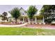 Charming home with a large porch, trees, a red front door, and green shutters on a well-manicured lawn at 10809 Arrowtree Blvd, Clermont, FL 34715