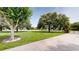 Expansive front yard with mature trees, a long driveway, a gated entry, and well-maintained landscaping at 10809 Arrowtree Blvd, Clermont, FL 34715