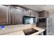 Kitchen features dark cabinets, a cooktop, microwave, tile backsplash and stainless-steel refrigerator at 10809 Arrowtree Blvd, Clermont, FL 34715